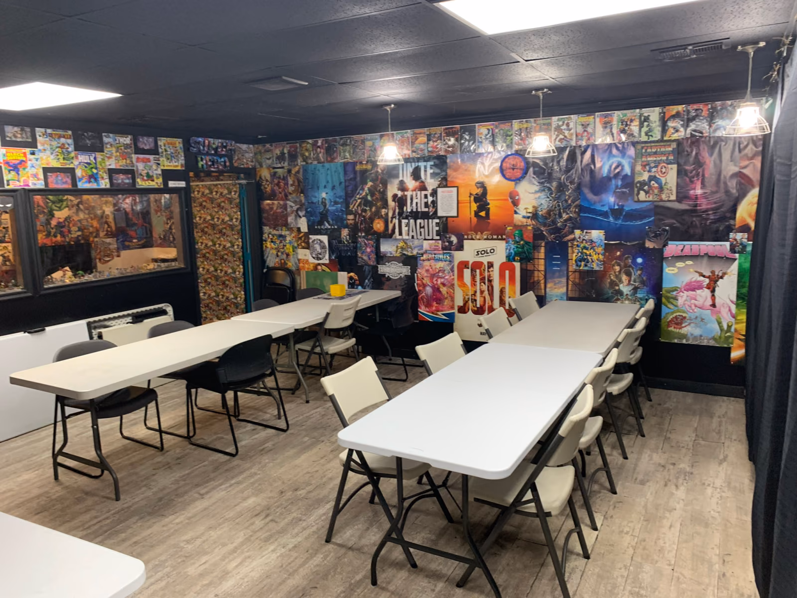 The game room, with long tables and chairs and comic art covering the walls