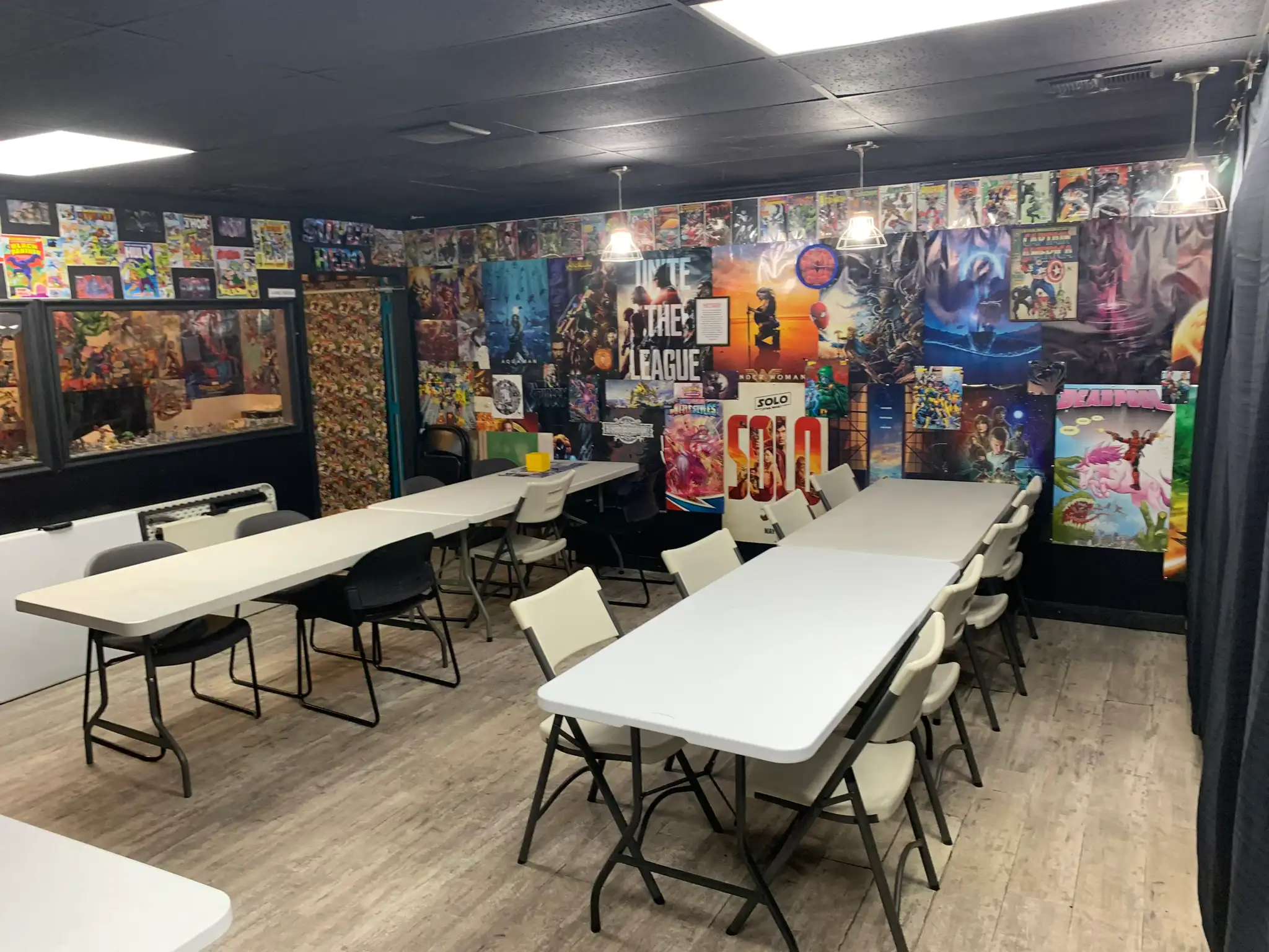 The game room, with long tables and chairs and comic art covering the walls