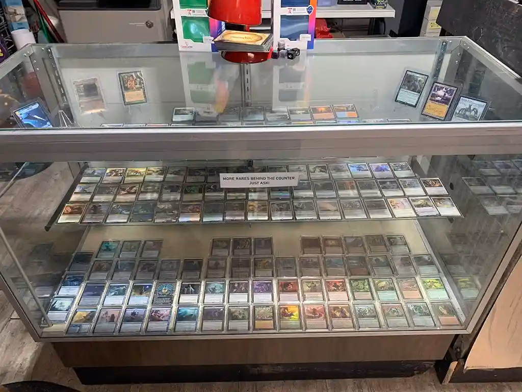 A glass display case full of trading card singles