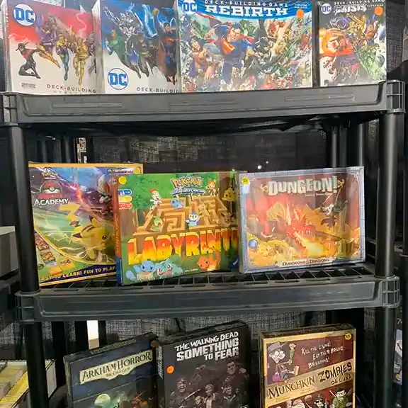 DC Comics and fantasy board games on a shelf