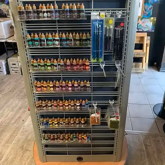 Hobby paints and brushes on a display rack