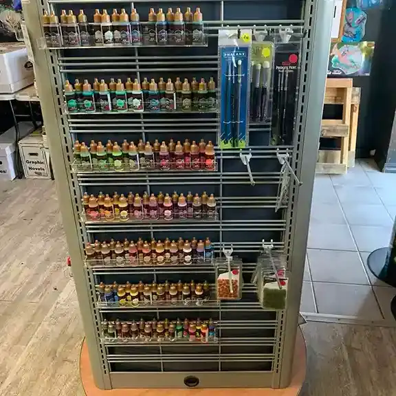 Hobby paints and brushes on a display rack